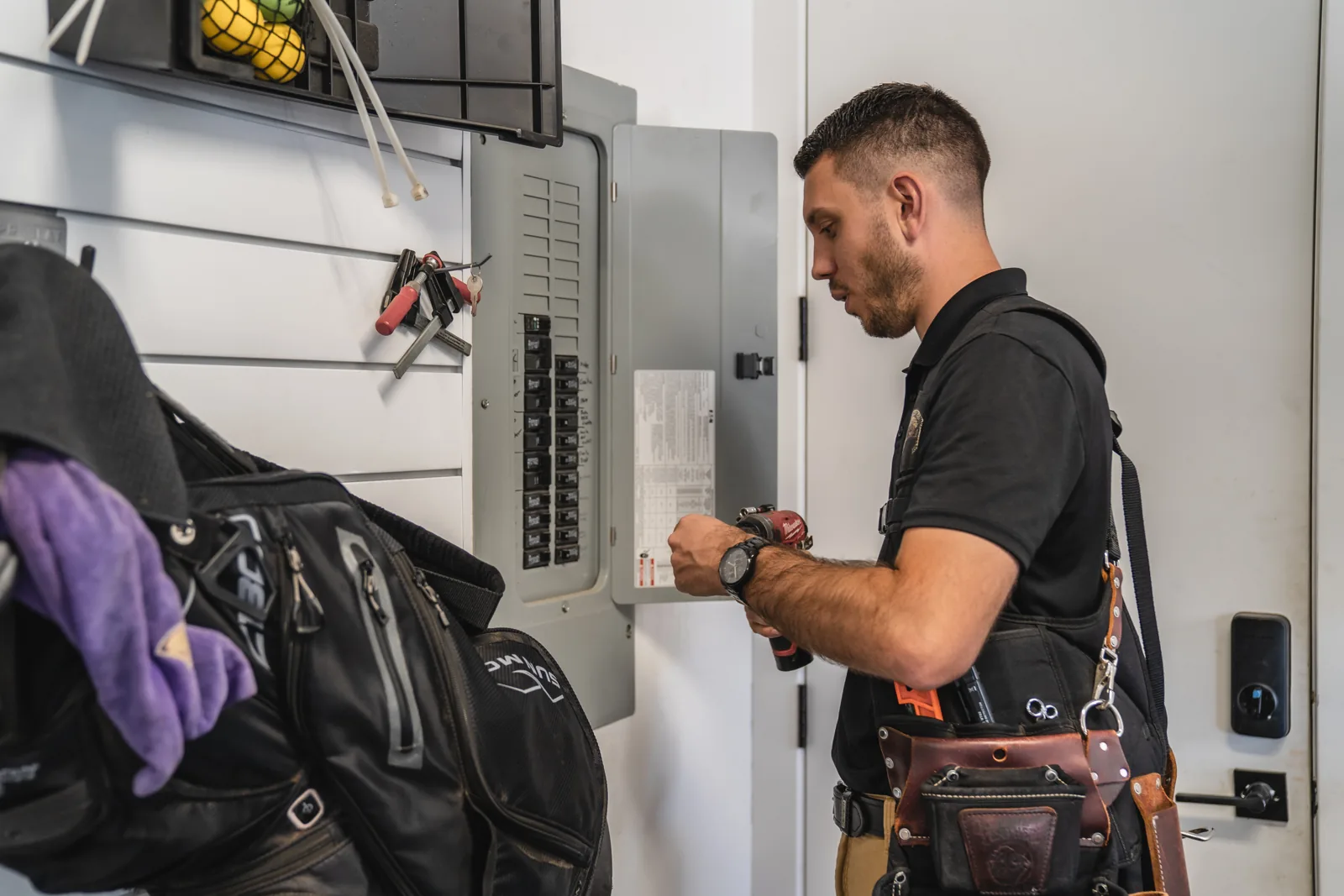 Inspector checking an electrical panel inside a garage